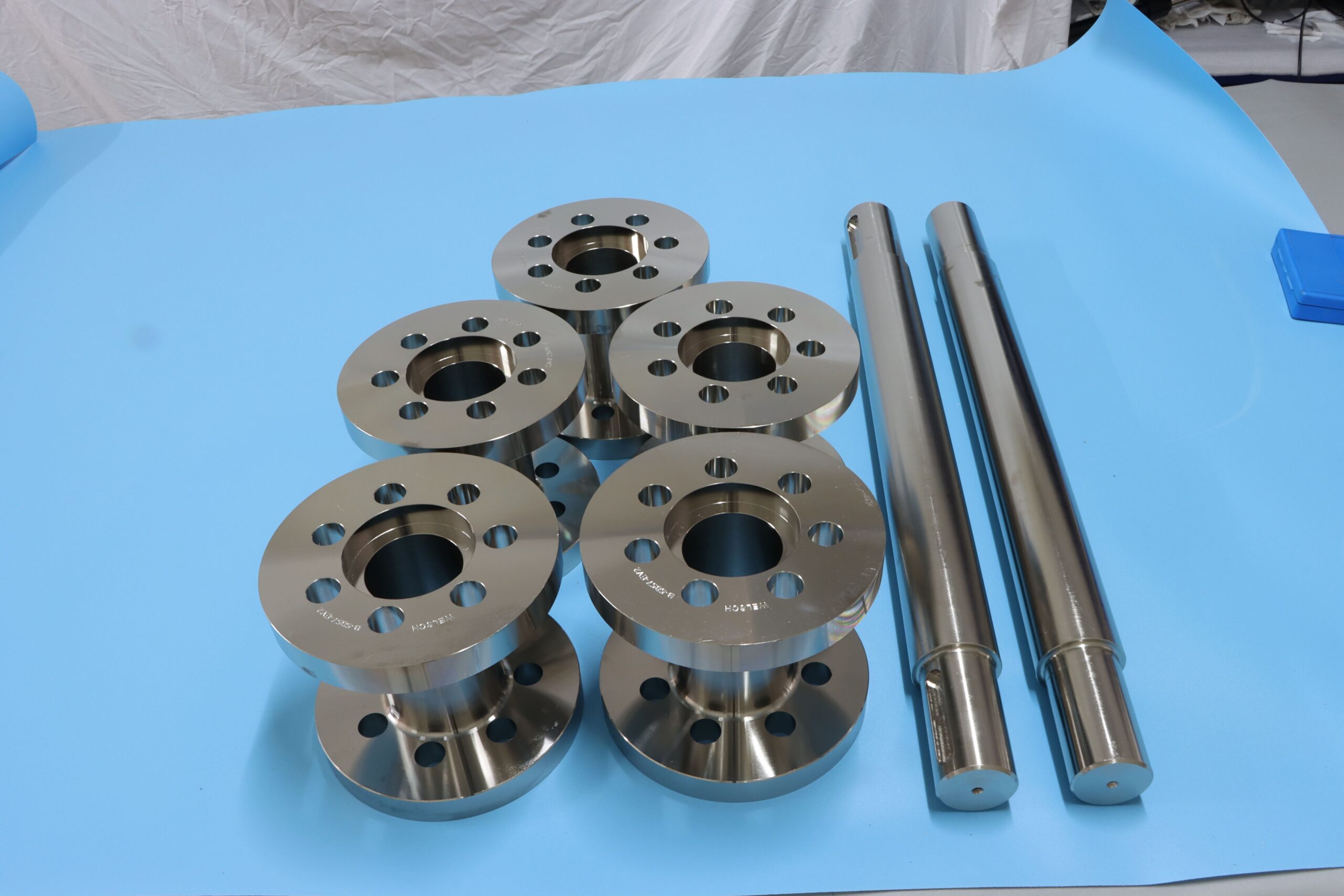 Precision CNC machined steel flanges and drive shafts for heavy-duty industrial transmission systems.
