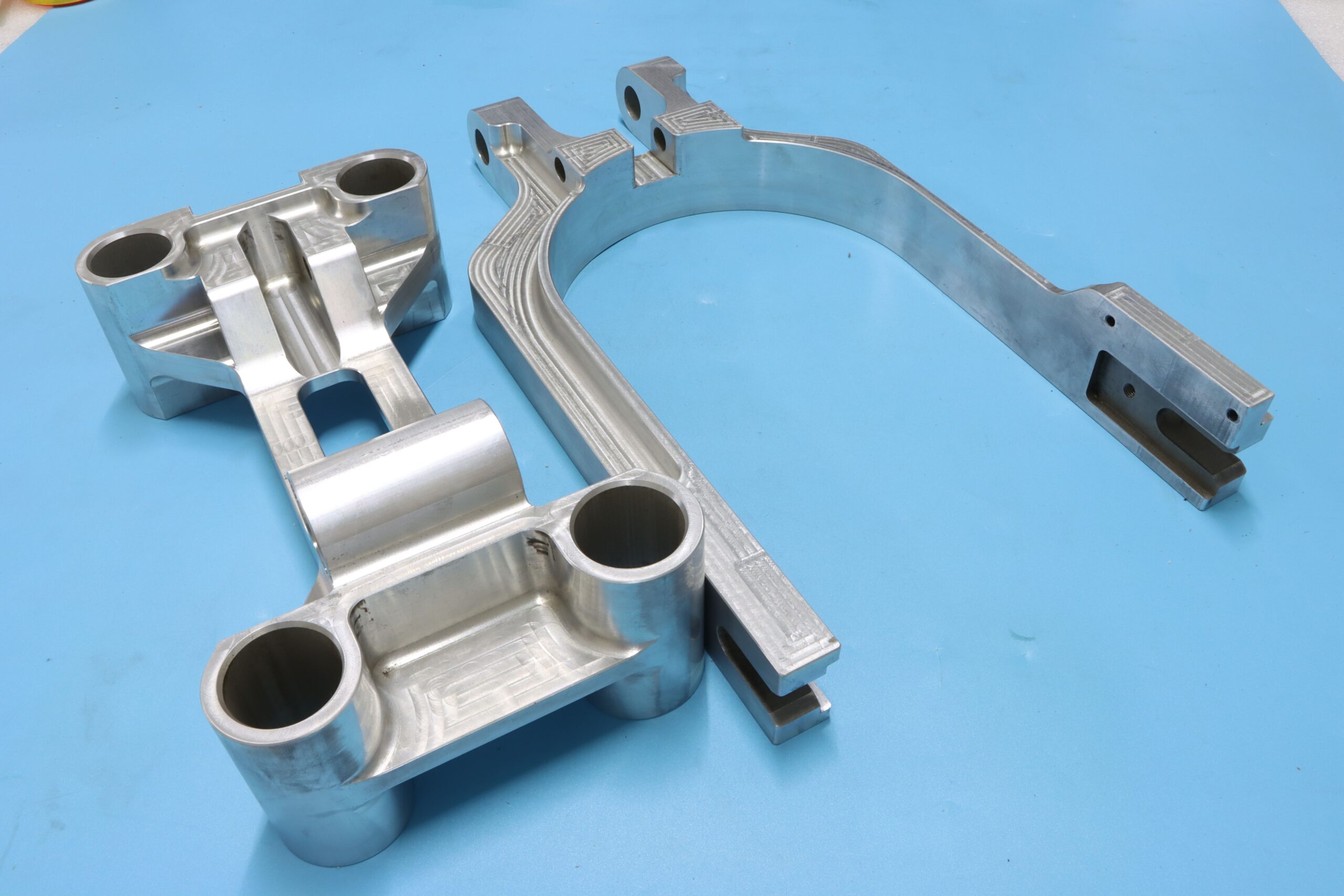 Custom heavy-duty CNC milled aluminum mechanical brackets showcasing precise tool paths and bored holes.