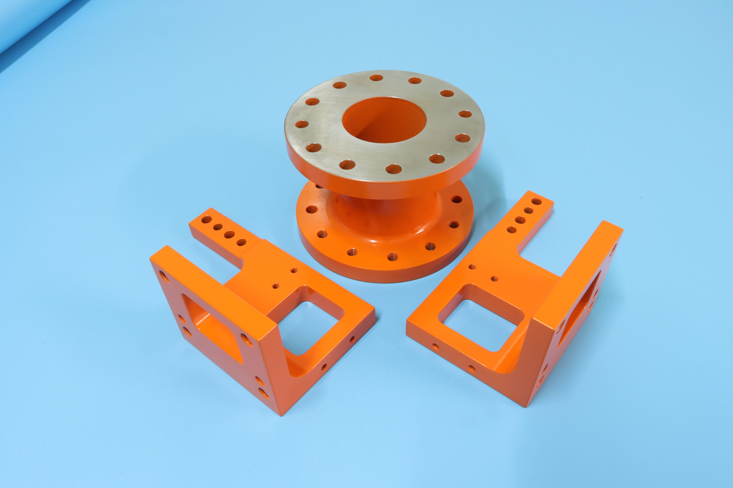 Custom precision powder coated machined parts with high-quality orange finish for industrial applications.