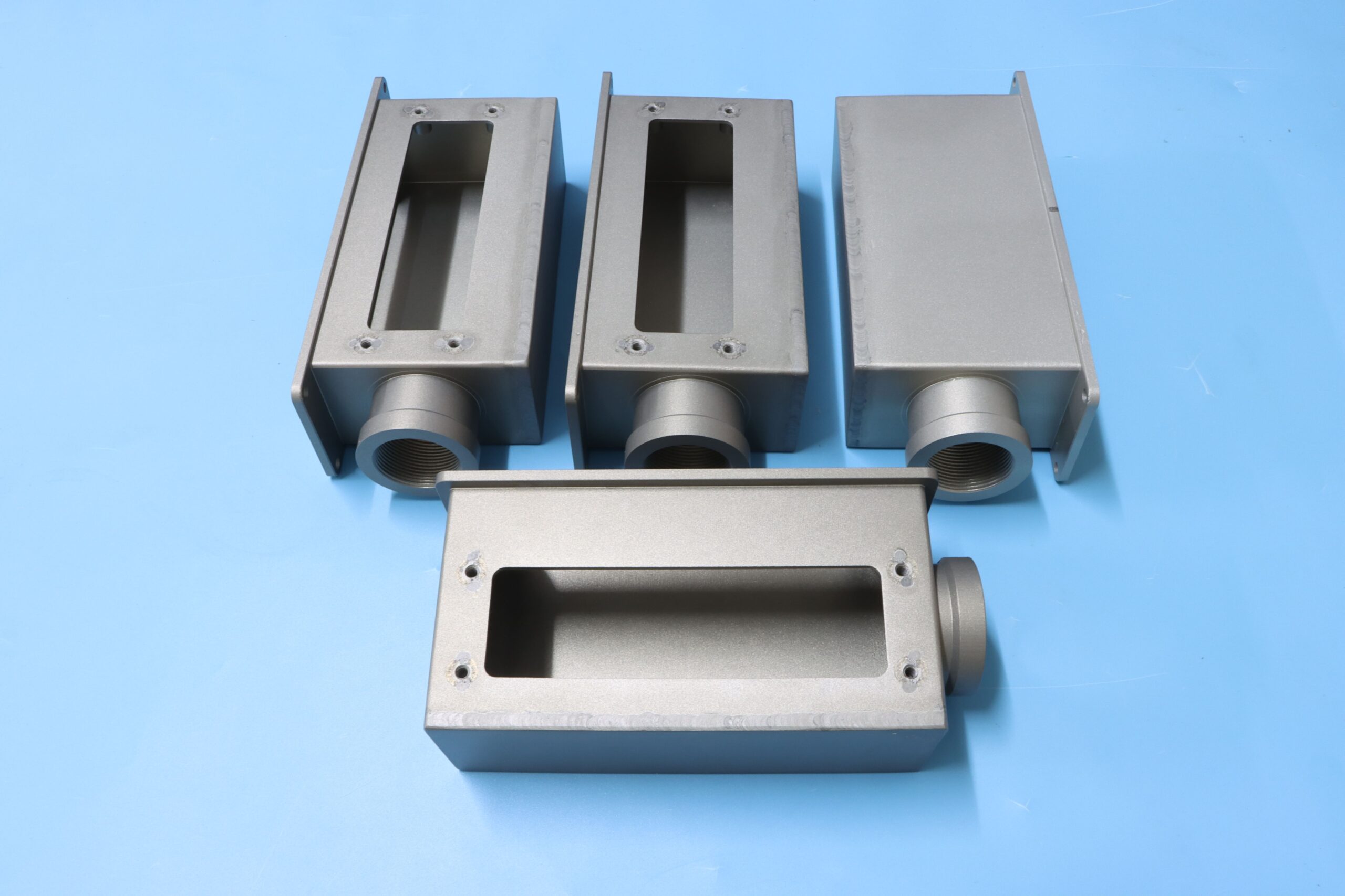 Custom fabricated and welded stainless steel electronic enclosures with threaded couplings.